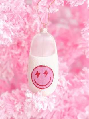 Pink glass slipper Christmas ornament with smiley face.
