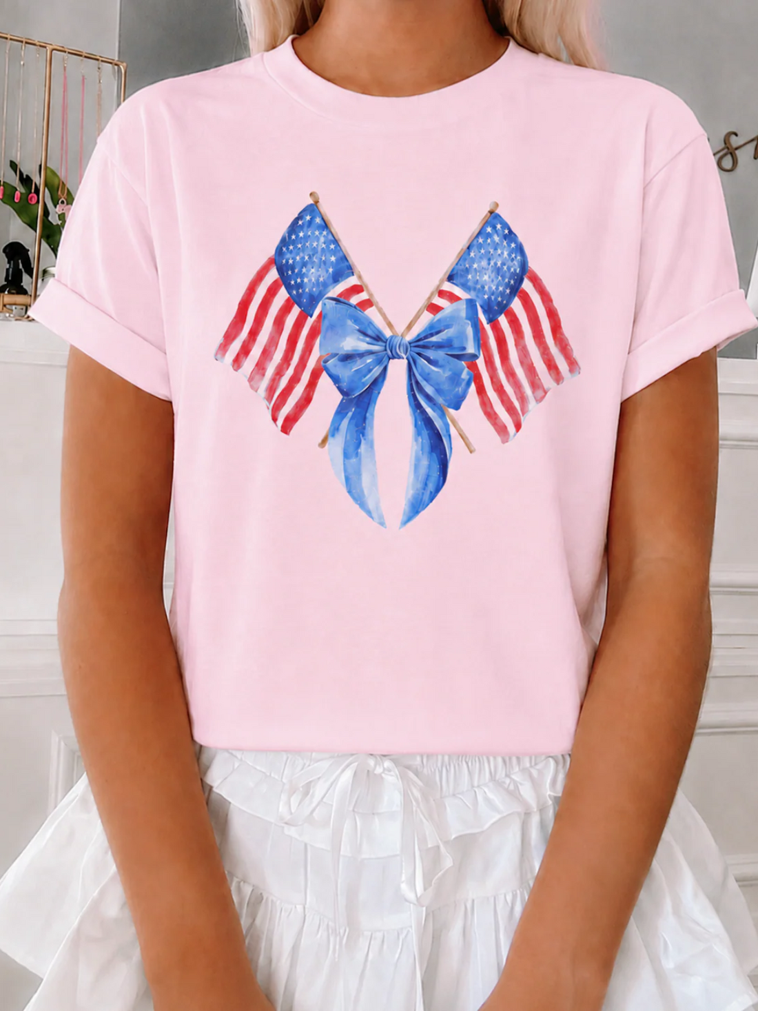 Model wearing a pink t-shirt with a blue bow and American flag design. Liberty Tee from Sassy Shortcake