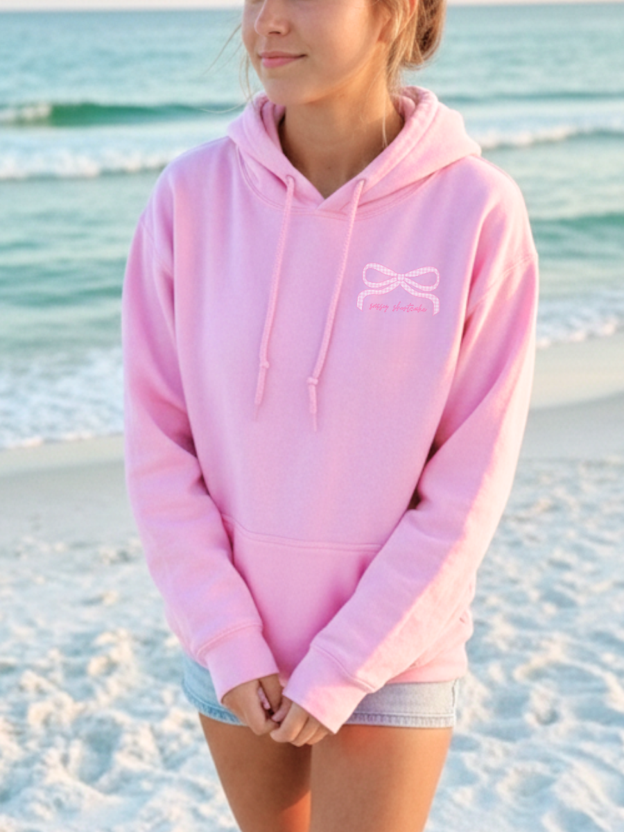 Sassy Gingham Bow Hoodie in pink from Sassy Shortcake featuring a relaxed oversized pullover silhouette with a prominent preppy gingham bow graphic design.