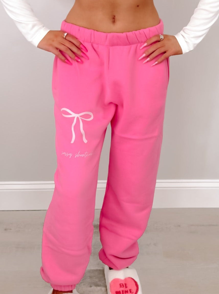 Pink Sassy Shortcake bow sweatpants with white bow detail.
