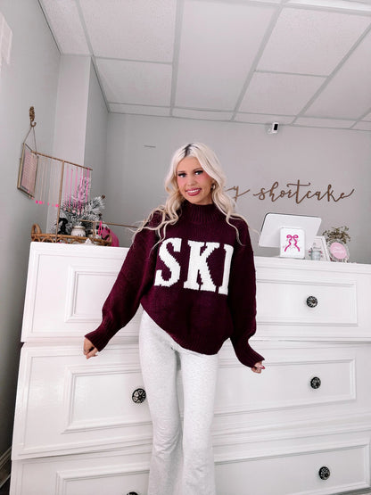 Après Ski Sweater - Sassy Shortcake - burgundy SKI graphic sweater full outfit view with white jeans