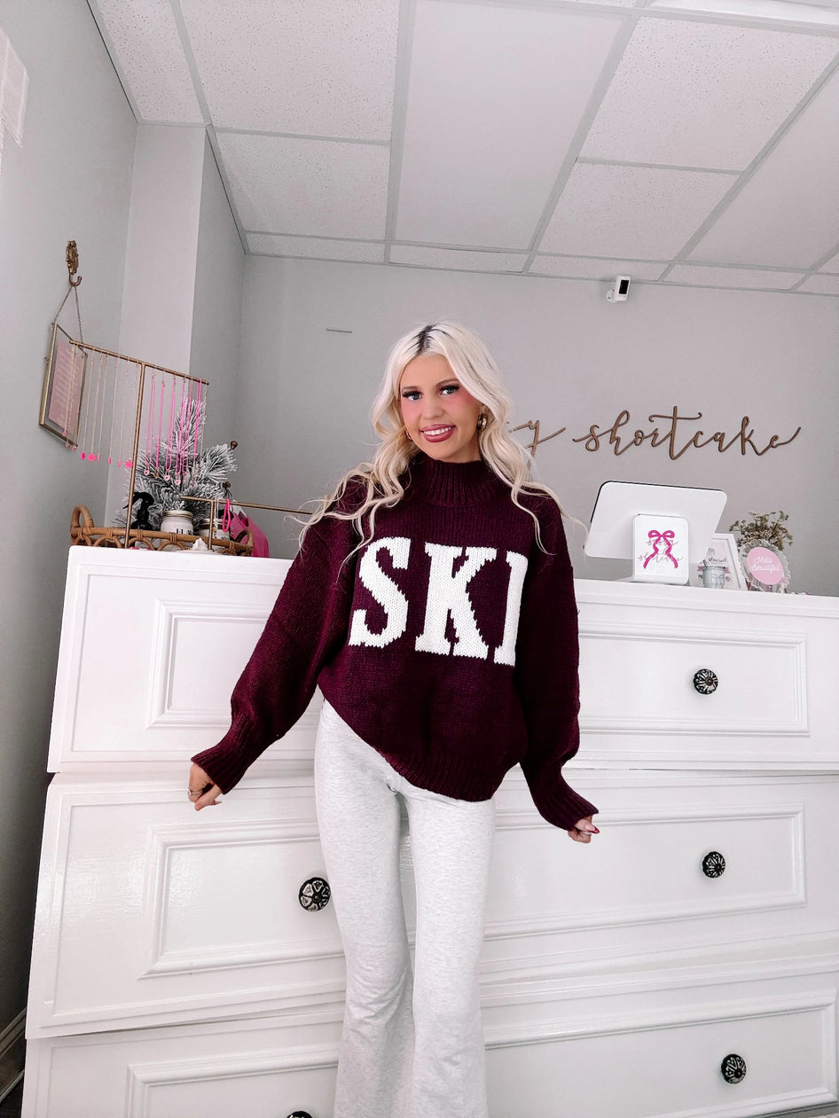 Après Ski Sweater - Sassy Shortcake - burgundy SKI graphic sweater full outfit view with white jeans
