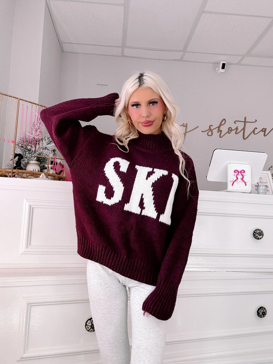 Après Ski Sweater - Sassy Shortcake - burgundy ski trip sweater styled pose hand in hair