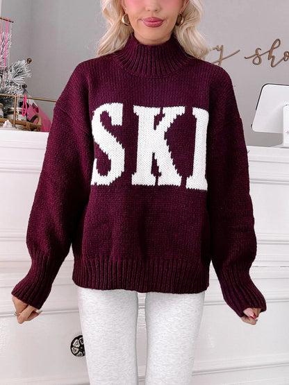 Après Ski Sweater - Sassy Shortcake - close-up of burgundy knit sweater with white SKI lettering