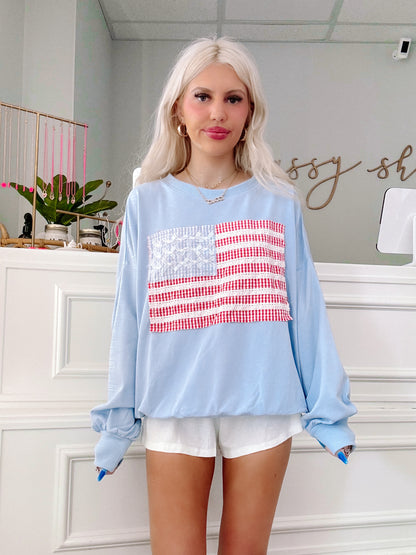 Front view of Sassy Shortcake’s Stars & Stitches Crewneck styled with white shorts.