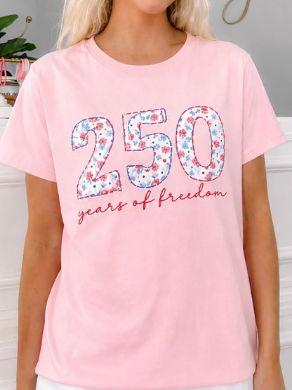 Close-up of Sassy Shortcake Sweet Liberty 250 Tee featuring floral 250 years of freedom patriotic graphic on a pink crewneck t-shirt