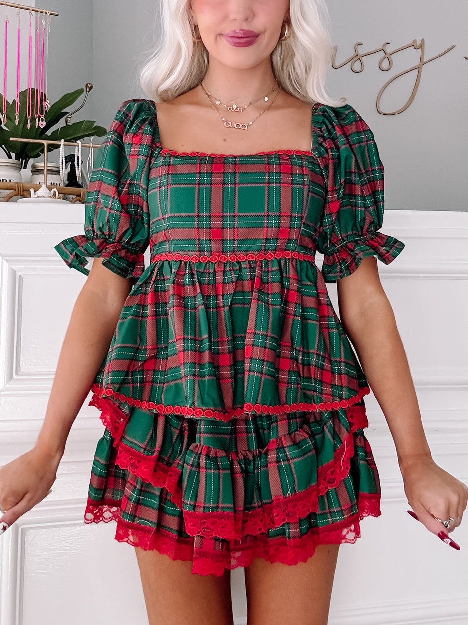 Green and red plaid top with puff sleeves and layered ruffle trim.
