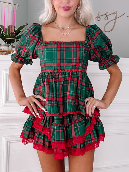 Red and green plaid mini dress with puff sleeves and layered red lace trim.
