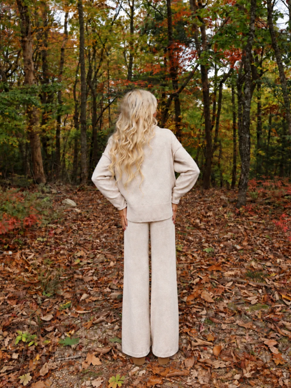 Back view of the Toasted Almond Knit Set by Sassy Shortcake showing the mock neck, dropped shoulders, and exposed seam details on the oatmeal knit sweater.
