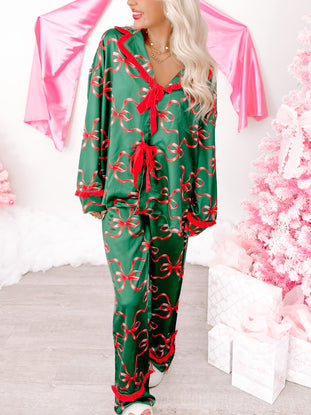 Green satin Twinkle & Tied pajama set with red ribbon bows; perfect for cozy nights.
