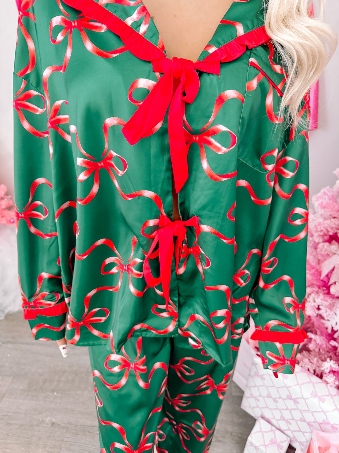 Green satin pajama set adorned with festive red ribbons and bows, perfect for cozy holiday nights. Twinkle & Tied pajama set from Sassy Shortcake 
