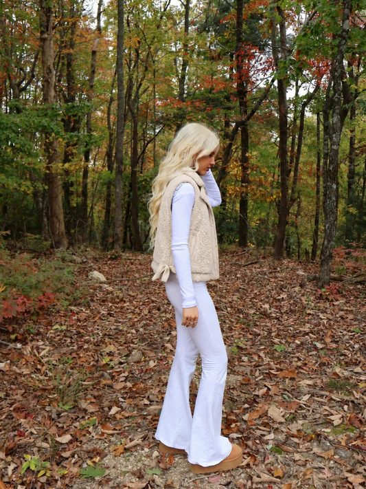 Side view of the Sassy Shortcake Vanilla Bean Bow Vest showing the fluffy cream teddy fleece, collar, and bow detail.
