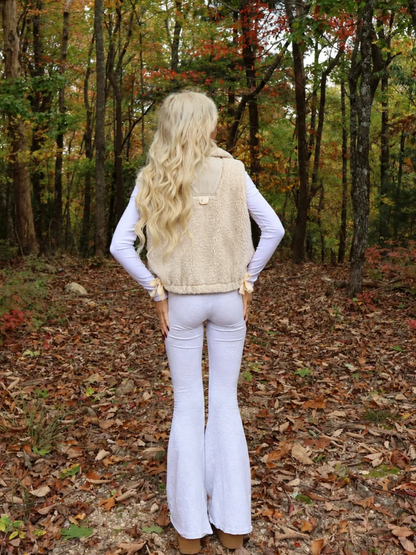 Back view of the Vanilla Bean Bow Vest by Sassy Shortcake showing the cream sherpa fabric and back details.
