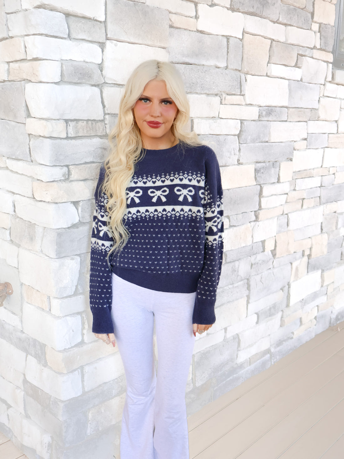 Sassy Shortcake Alpine Angel Navy Bow Sweater, a cozy knit with a round neckline and a large white bow and heart graphic on the front.