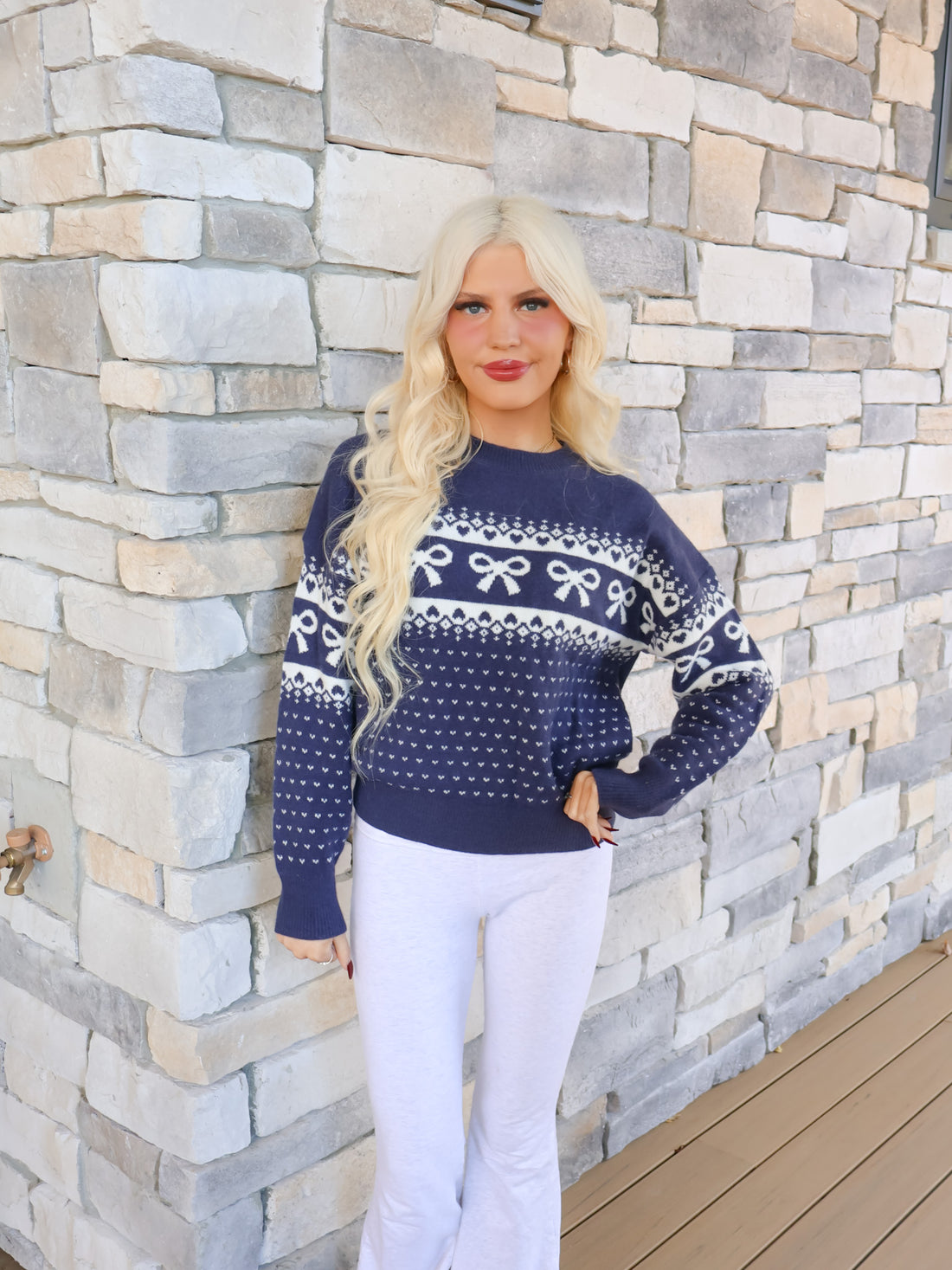 Cozy navy knit sweater with a festive white bow and heart pattern, modeled on figure for Sassy Shortcake.
