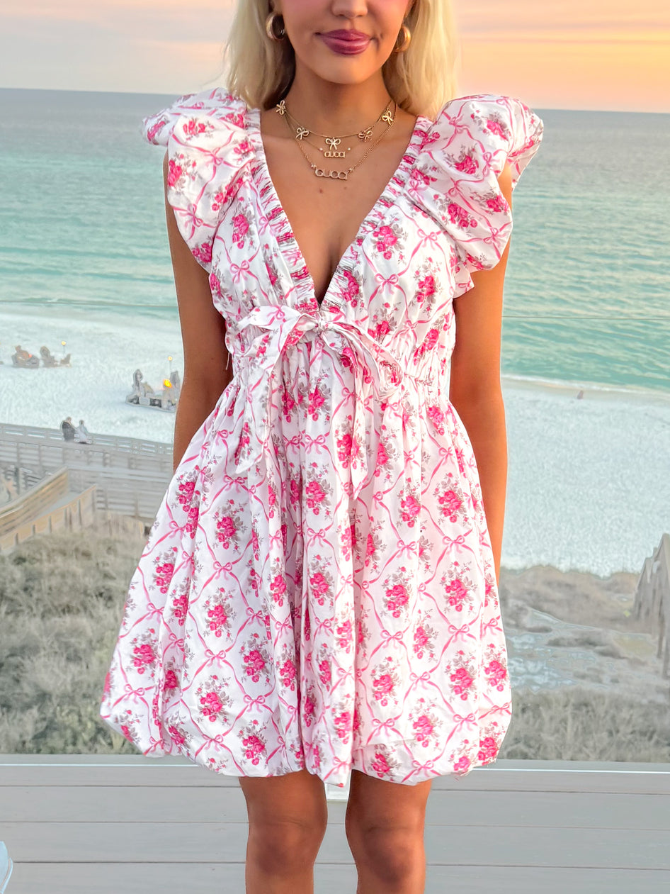 Ayla Floral Bow Dress: Pink floral print mini dress with puffed sleeves and bow detail.
