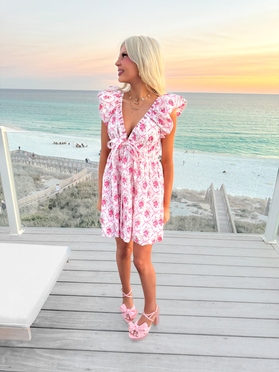 Floral print mini dress, worn on a deck overlooking the ocean at sunset.
