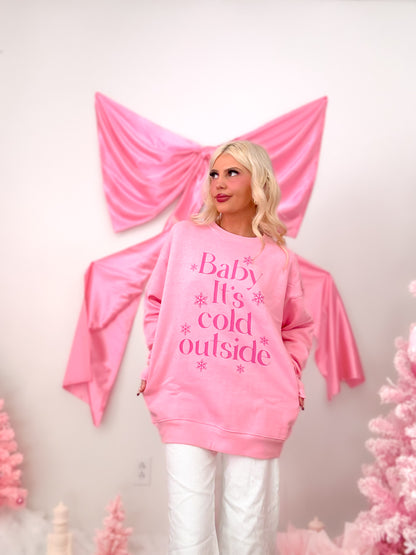 Close-up of the front of the pink crewneck, highlighting the hot pink "Baby It's Cold Outside" text and snowflake print.
