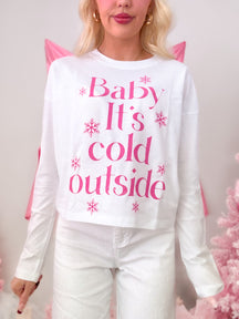 White short-sleeve t-shirt with a seasonal hot pink graphic that reads 'Baby It's Cold Outside,' modeled on figure.