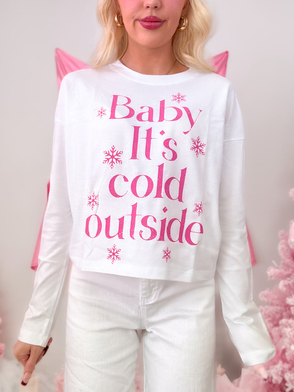 White short-sleeve t-shirt with a seasonal hot pink graphic that reads 'Baby It's Cold Outside,' modeled on figure.