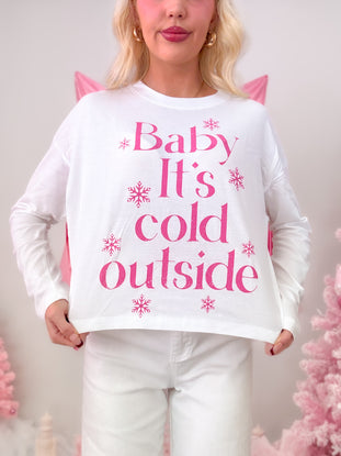 Model wearing a white t-shirt featuring a hot pink graphic of snowflakes and the phrase "Baby It's Cold Outside."