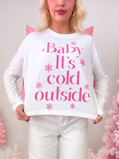 Model wearing a white t-shirt featuring a hot pink graphic of snowflakes and the phrase "Baby It's Cold Outside."