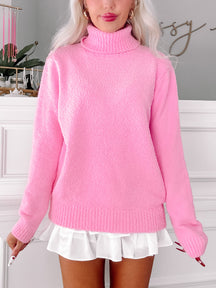 Pink fluffy turtleneck sweater styled with a white pleated skirt.
