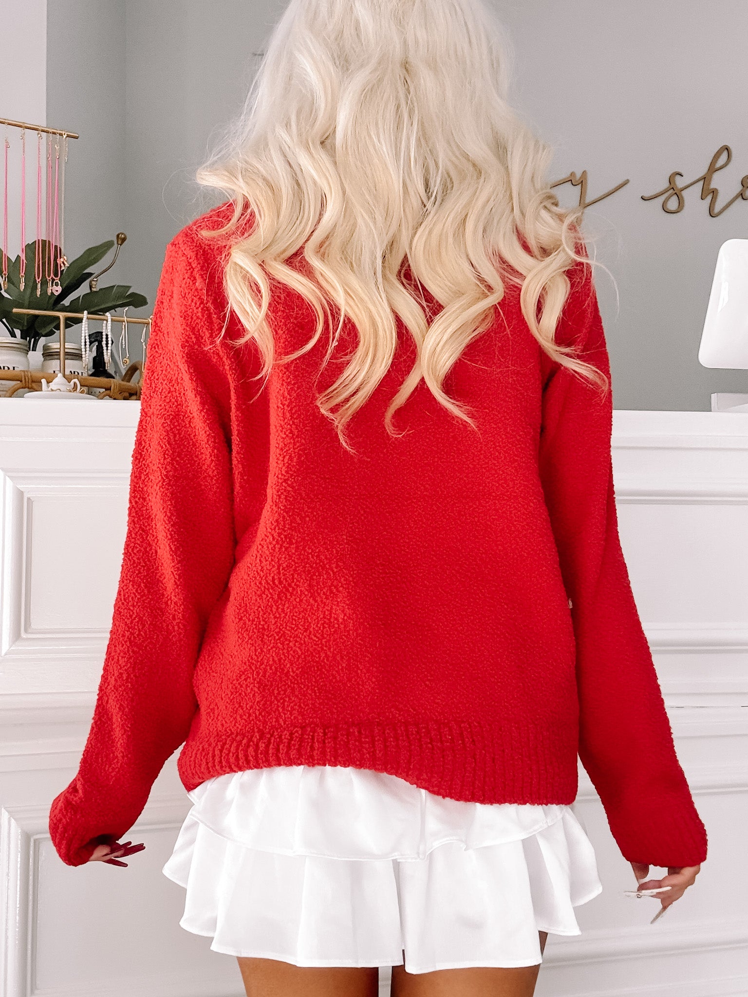 Red fuzzy knit sweater worn with a white ruffled skirt.
