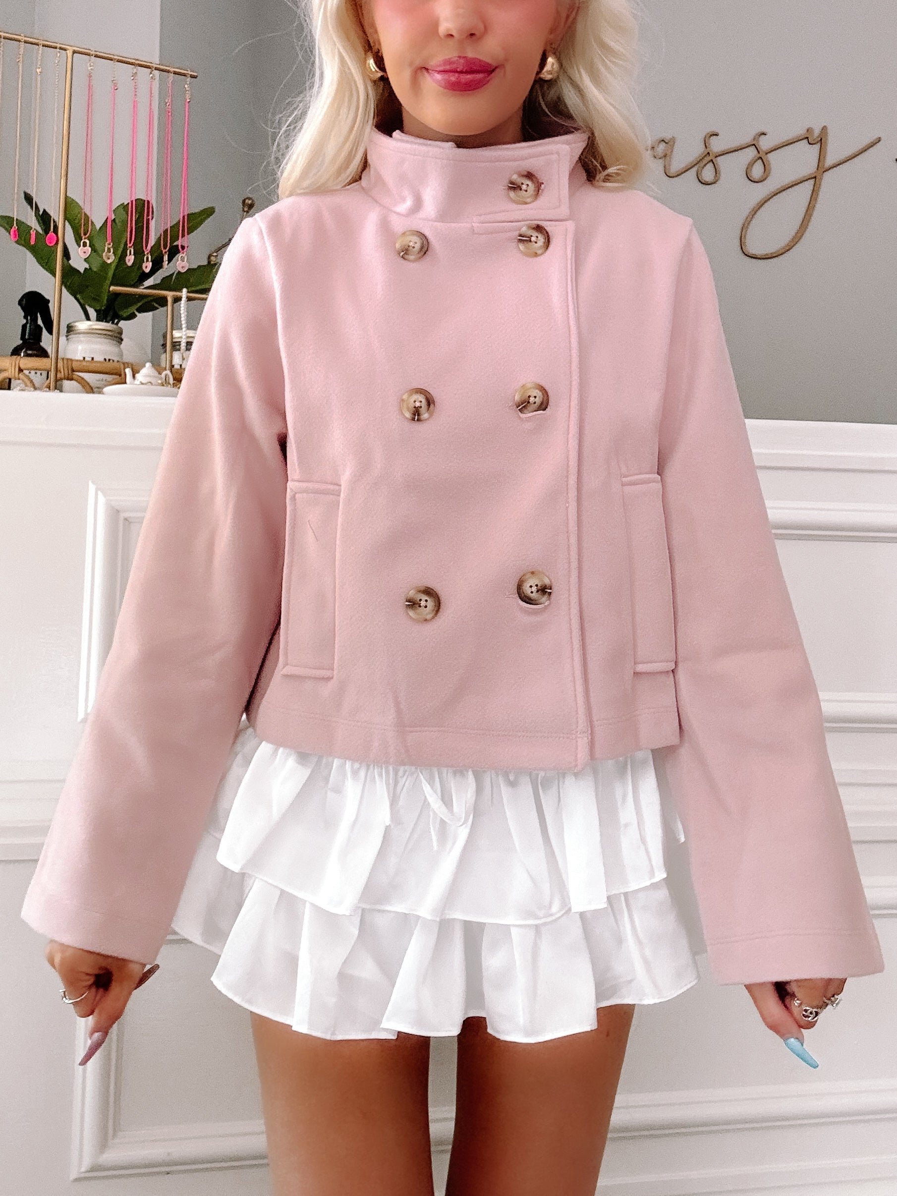 Pink Bespoke double-breasted cropped coat with wooden buttons.
