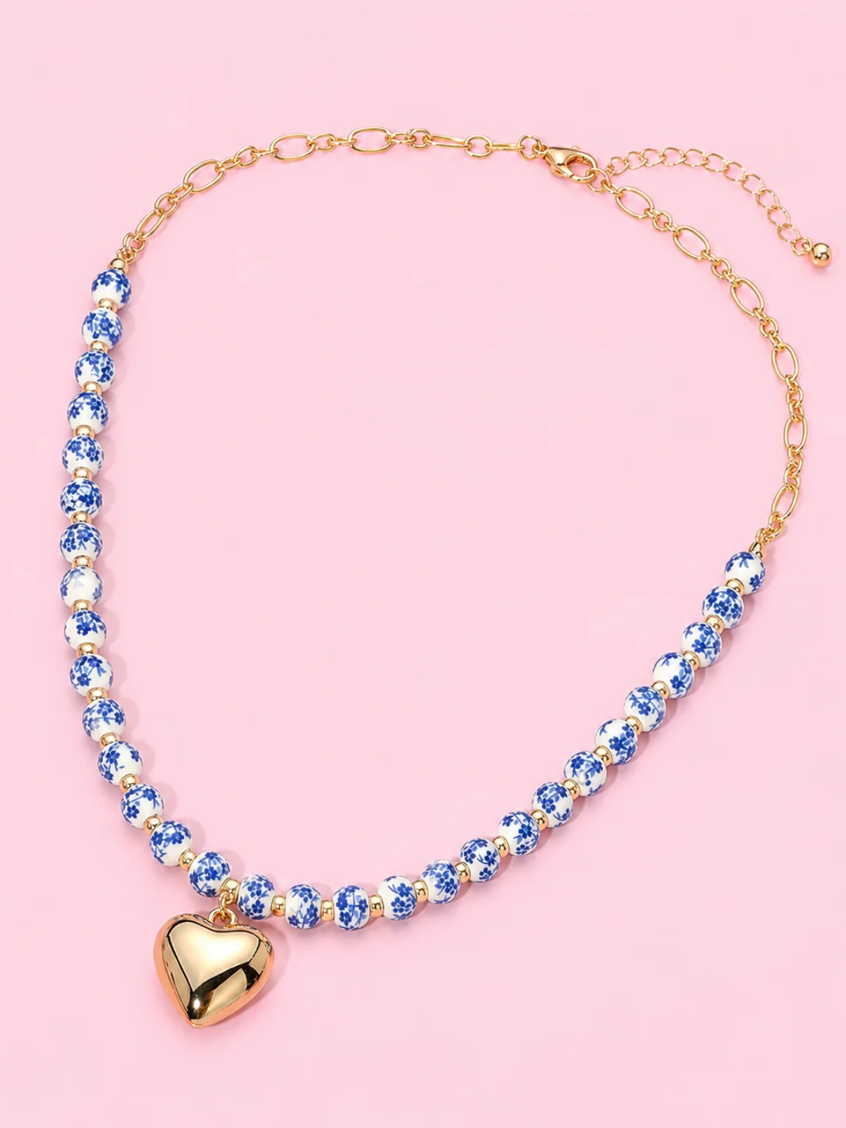 Blue Belle Heart Necklace from Sassy Shortcake - A beaded necklace featuring blue and white ceramic beads with a polished gold heartshaped pendant.