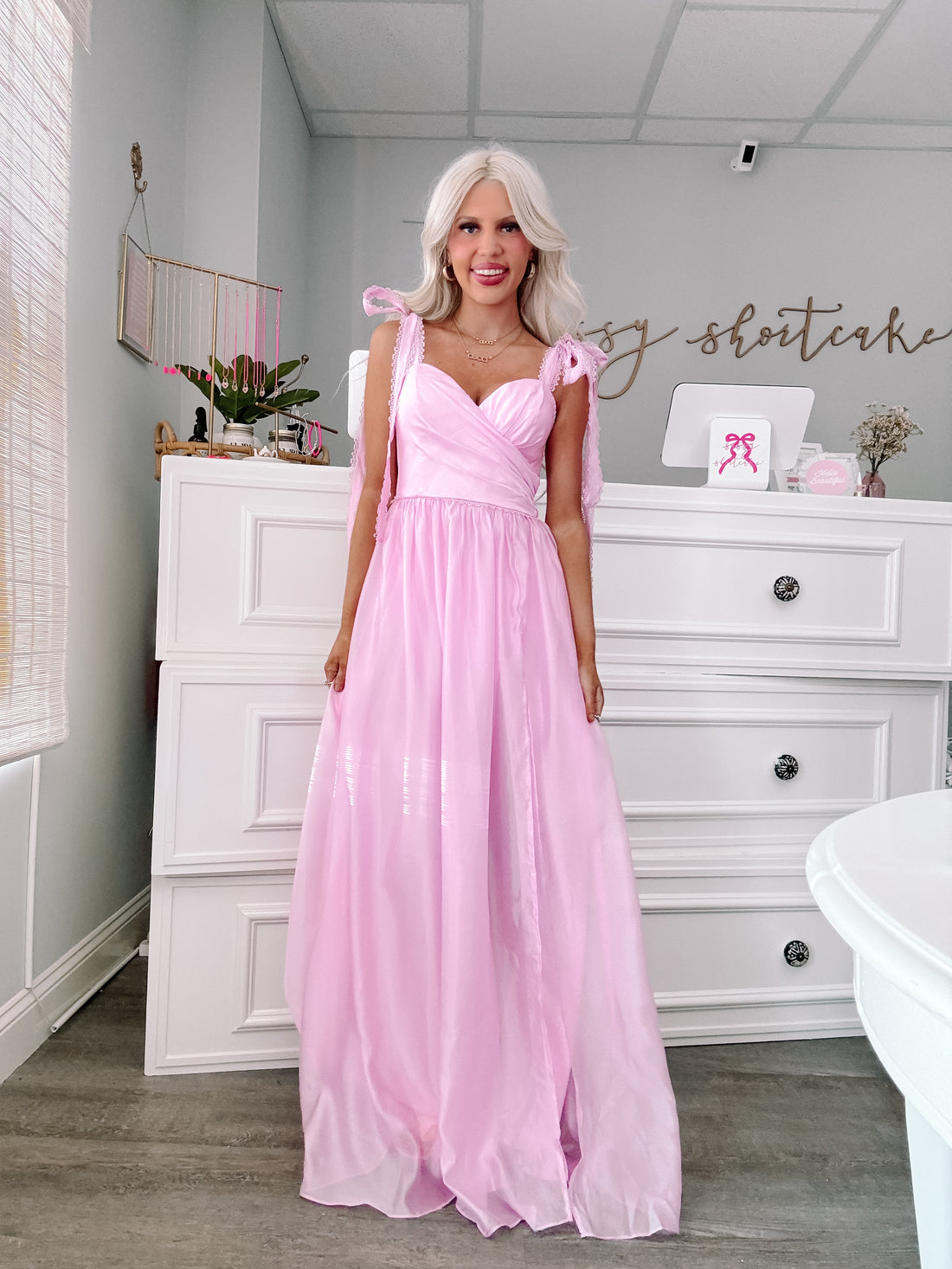 Side view of blush pink strapless ruffle formal dress with layered tulle skirt, feminine and flirty fit.