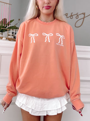 Orange Blushing Bow Crewneck sweatshirt with three white bows; Sassy Shortcake design.
