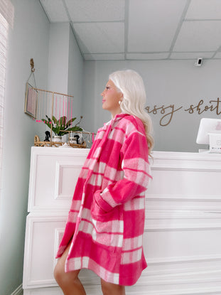 Pink and white checked jacket; cozy, oversized fit shown in a boutique.
