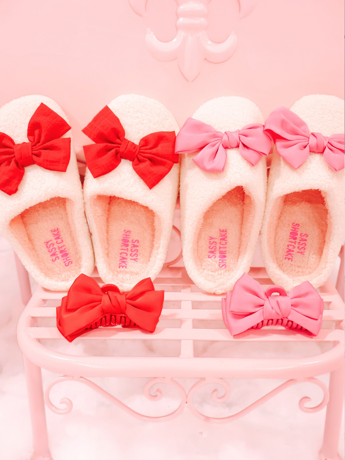Red and Pink Satin Bow Hair Clips by Sassy Shortcake – shown with red and pink slippers on display.