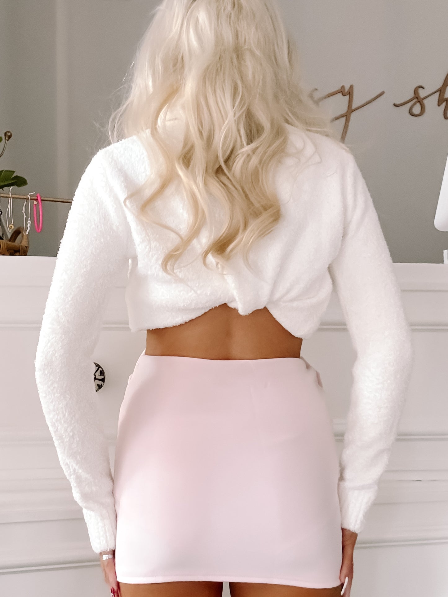 Pale pink mini skirt paired with a fluffy white cropped sweater.
