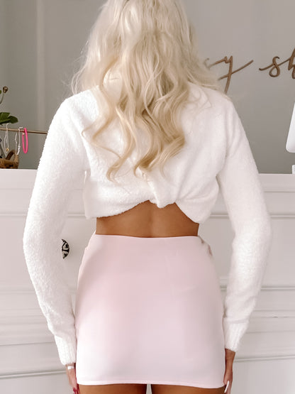 Pale pink mini skirt paired with a fluffy white cropped sweater.
