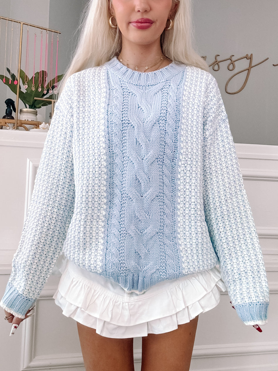 Breezy Blue Cable Knit Sweater: Pastel blue and white knit, featuring a cable knit detail.

