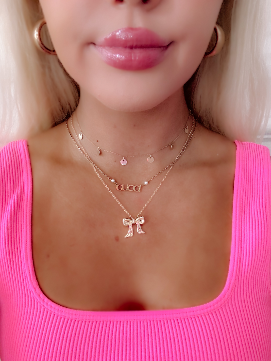 Gold Brynlee bow necklace layered with delicate gold chains.
