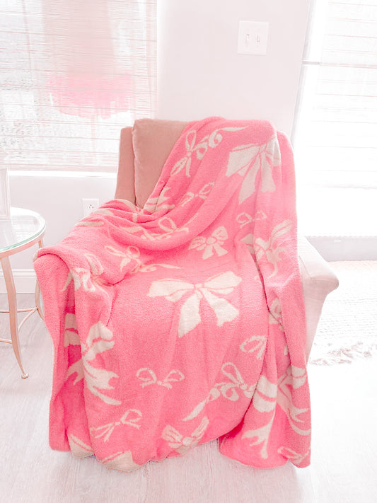 Bubblegum Pink Bow Blanket: Cozy, plush pink throw blanket with cream bow print.
