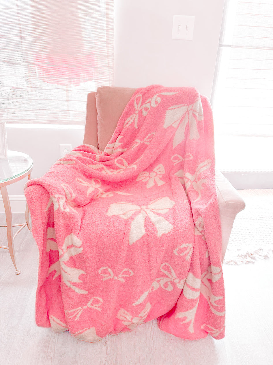Bubblegum Pink Bow Blanket: Soft, plush pink blanket with off-white bow pattern.
