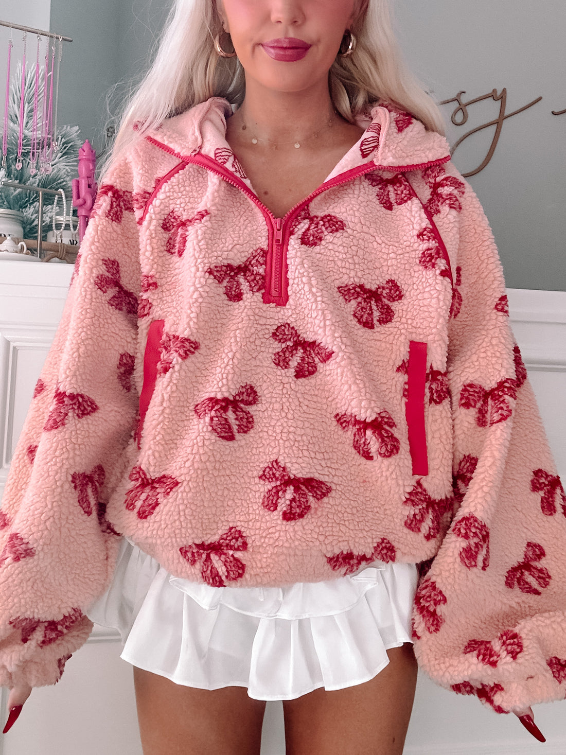 Pink Bundled in Bows pullover, cozy sherpa fleece with red bow print.
