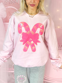 Pink Candy Cane Crewneck sweatshirt with sequined candy cane and bow detail.
