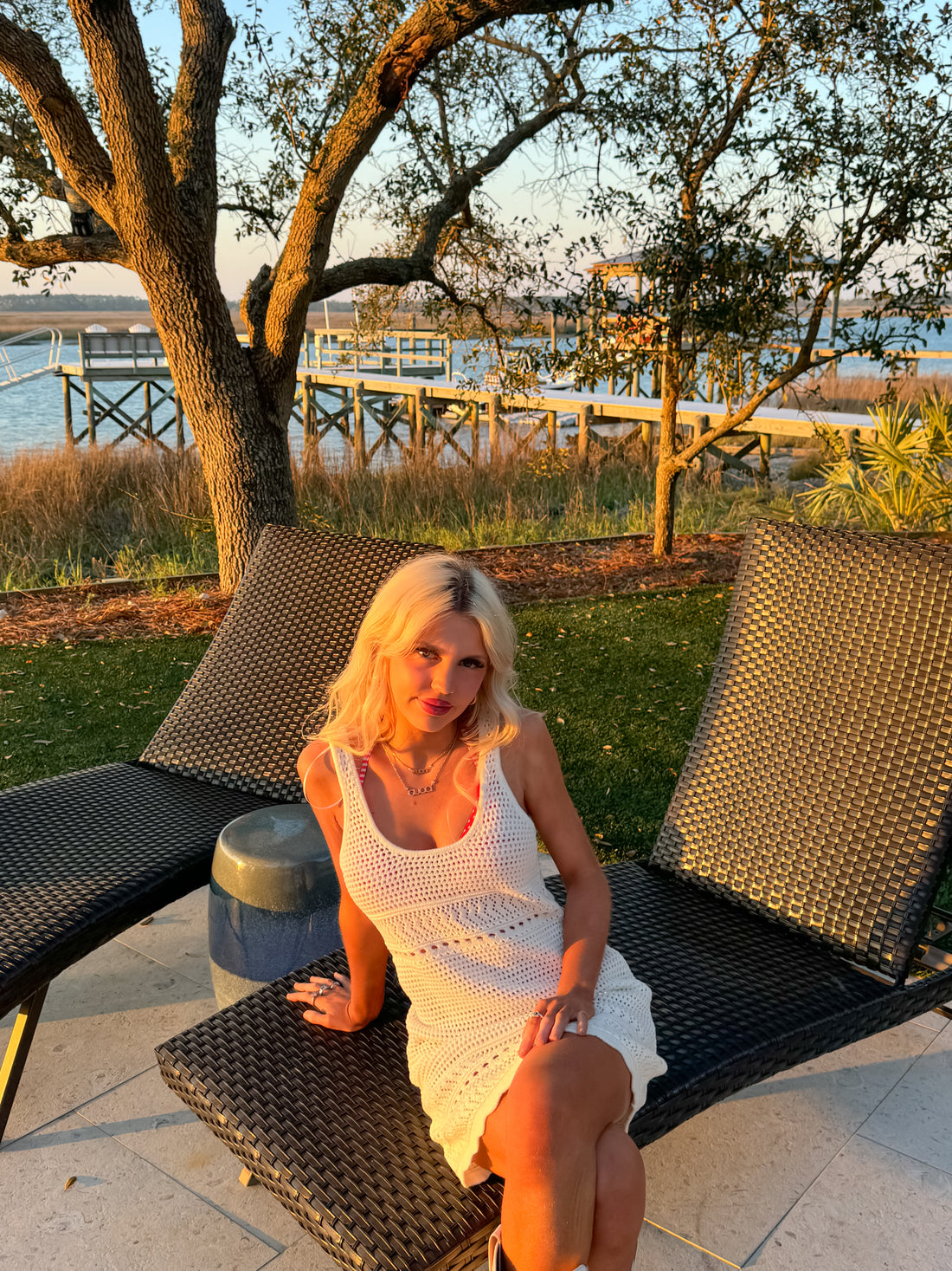 Model sitting poolside in crochet swim cover-up with breezy fit.