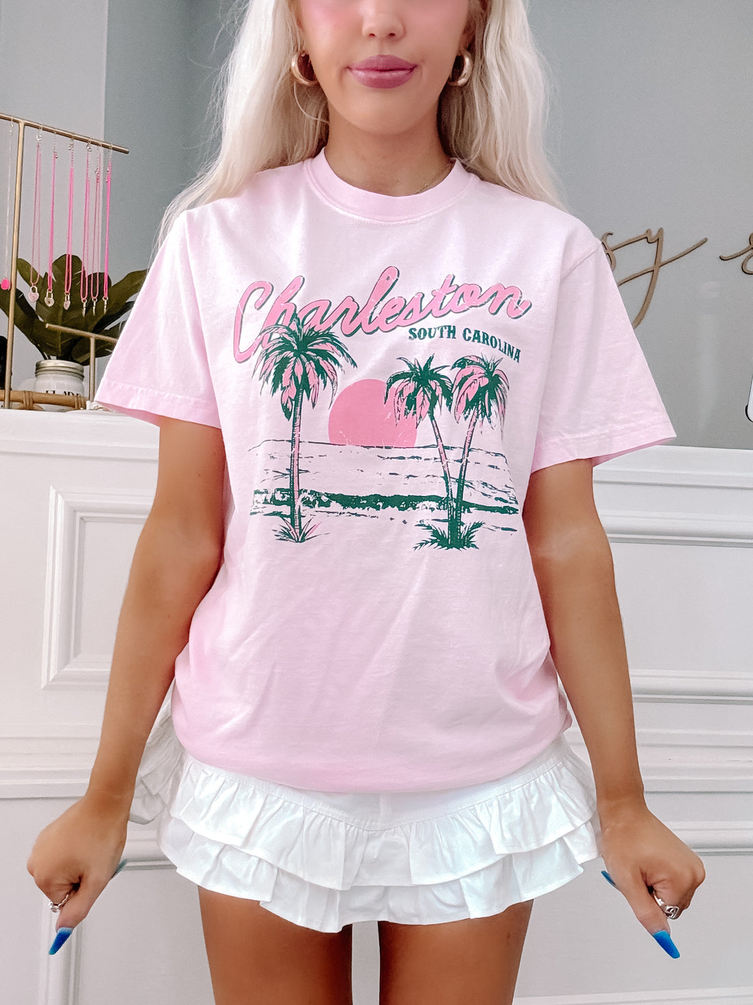 Model in Pink Charleston oversized tee with palm tree beach scene.