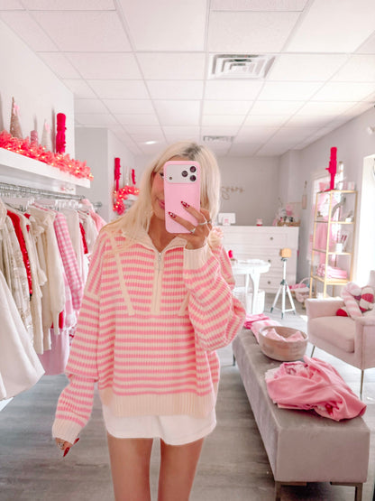Cozy By The Coast Pullover from Sassy Shortcake - Person wearing a pink and white striped sweater in a store