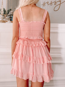Pink ruffle two-piece summer outfit; tiered skirt and smocked top.
