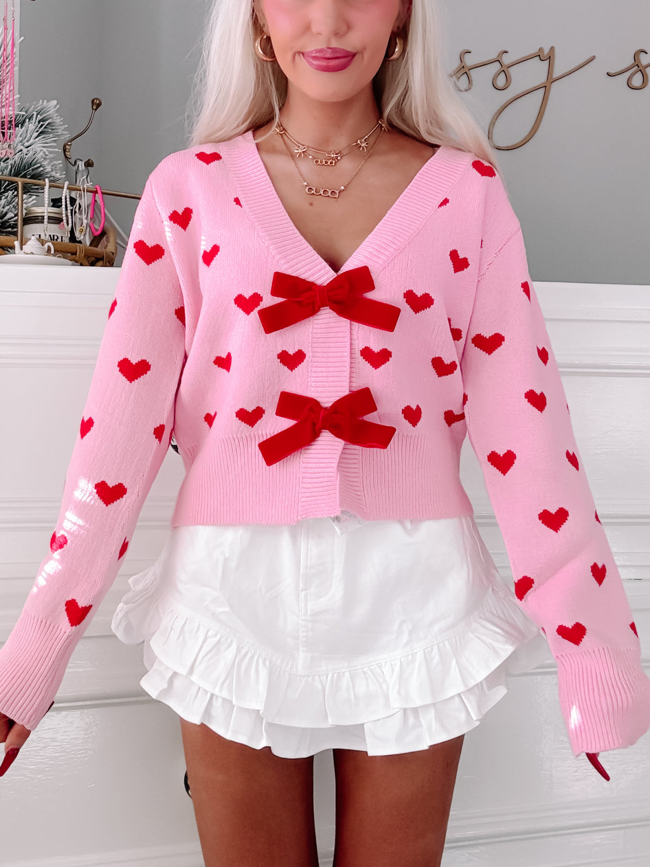 Pink Cupid's Bow cardigan with red hearts & velvet bows.
