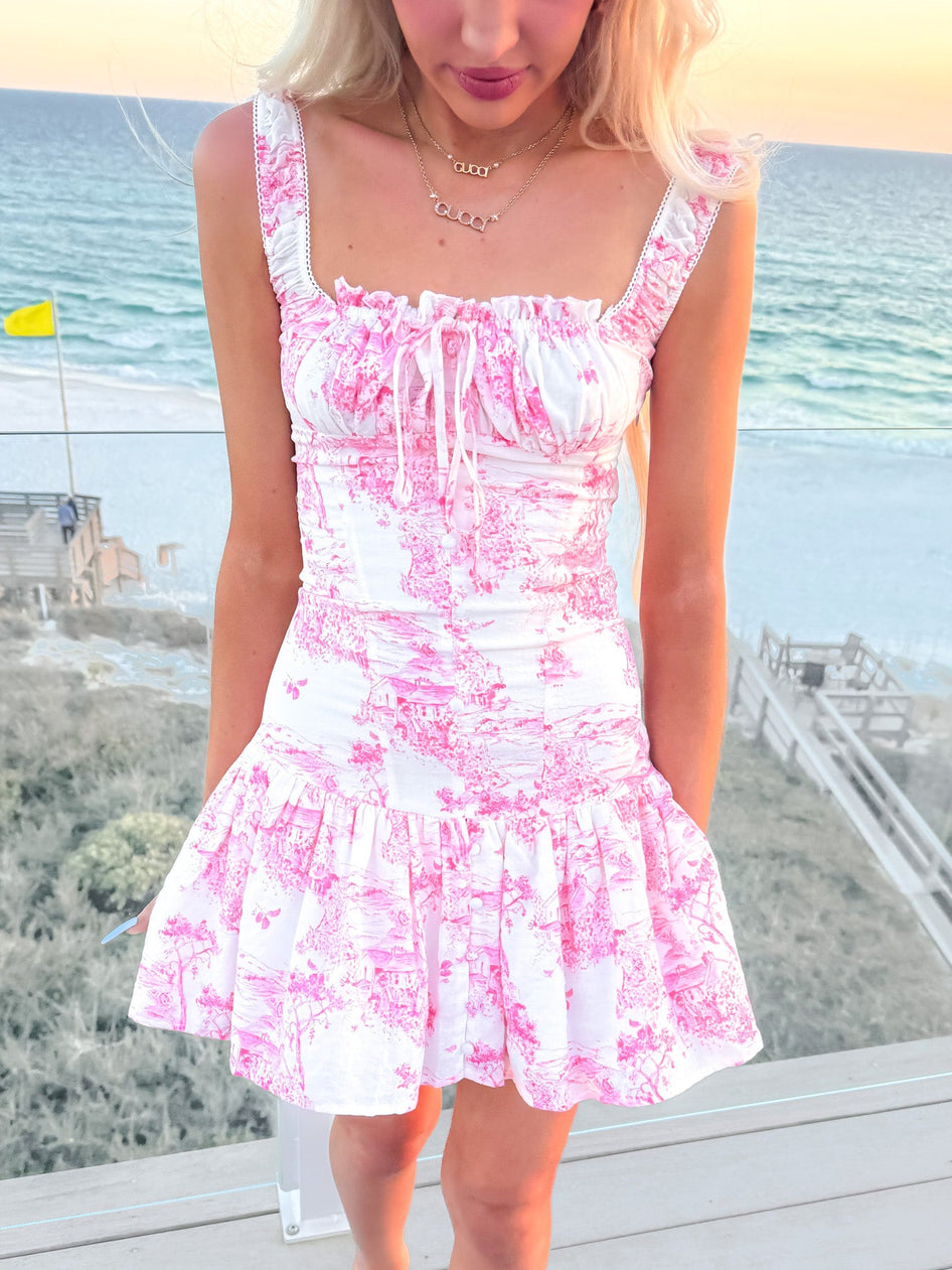 Pink Daphne Toile mini dress with ruffled neckline and tiered skirt.
