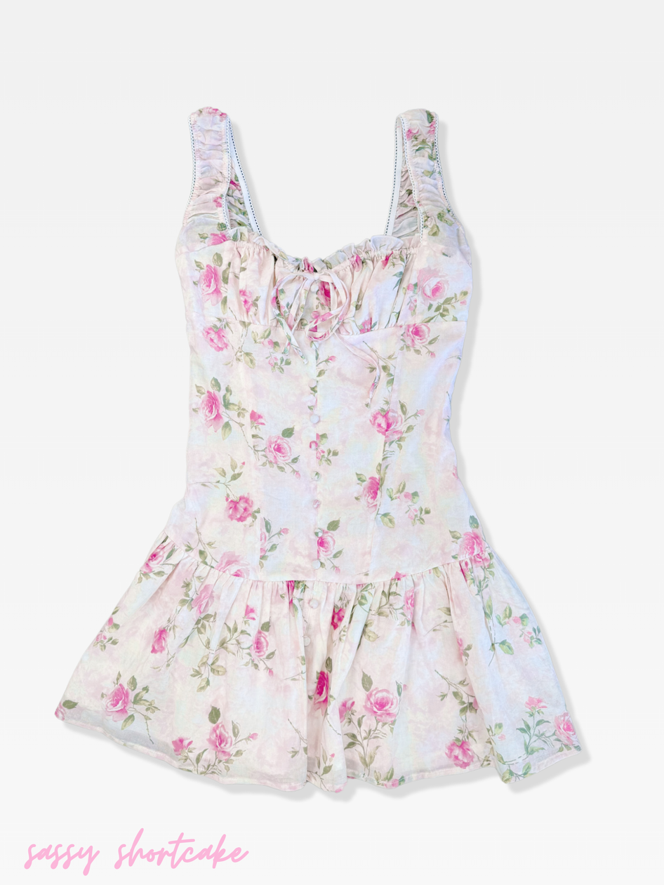 Pink floral dress with a ruffled hem and delicate straps.
