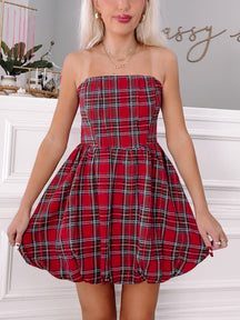Red and green plaid strapless mini dress, bubble hem, on a model.
